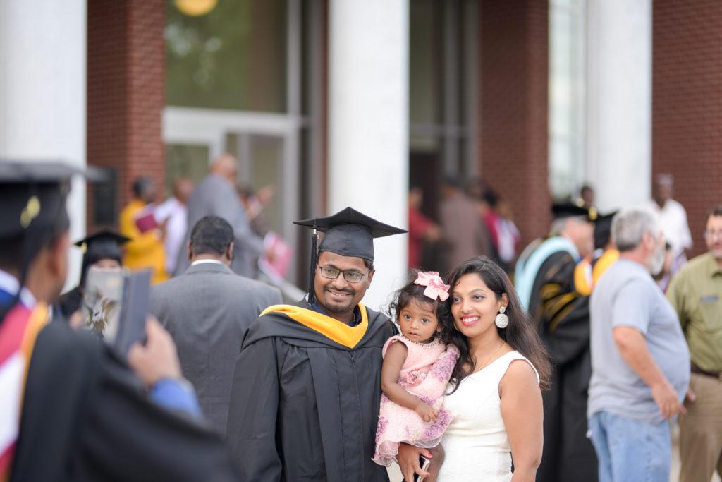 Ram Chandra Prusty of India, gets a photo taken with his wife, Geeta Varanasi, and daughter, Viviktha Prusty, after graduating from Campbellsville University. (Campbellsville University Photo by Joshua Williams)