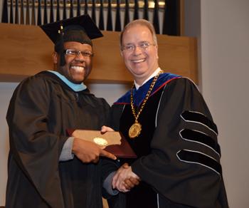 DeMarcus Compton, right, of Campbellsville receives his master of arts in special education degree from Dr.  Michael V. Carter, president. (Campbellsville University Photo by Christina Kern)